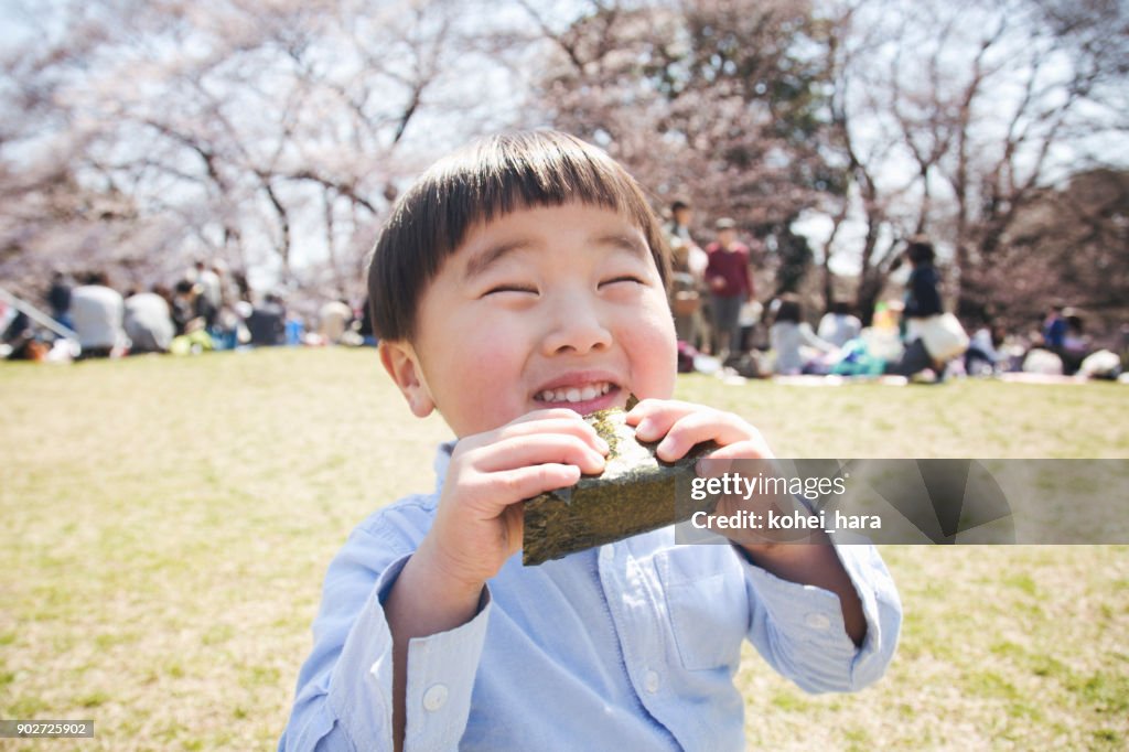 公園でご飯を食べる少年