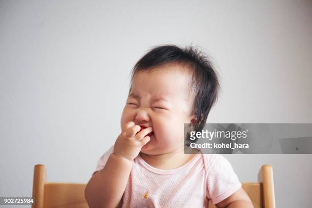 rostro sorprendido del bebé justo después de comer tomate por primera vez en su vida - asian baby eating fotografías e imágenes de stock
