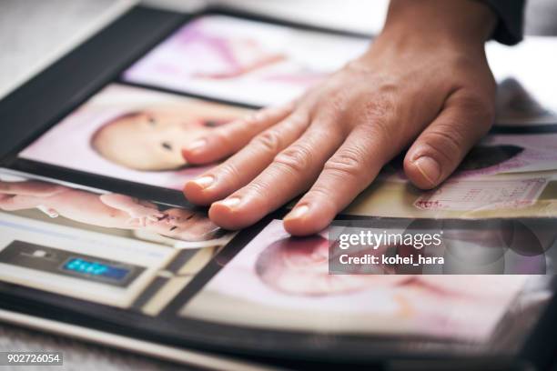 manos de mujer haciendo un álbum de fotos - album fotos fotografías e imágenes de stock