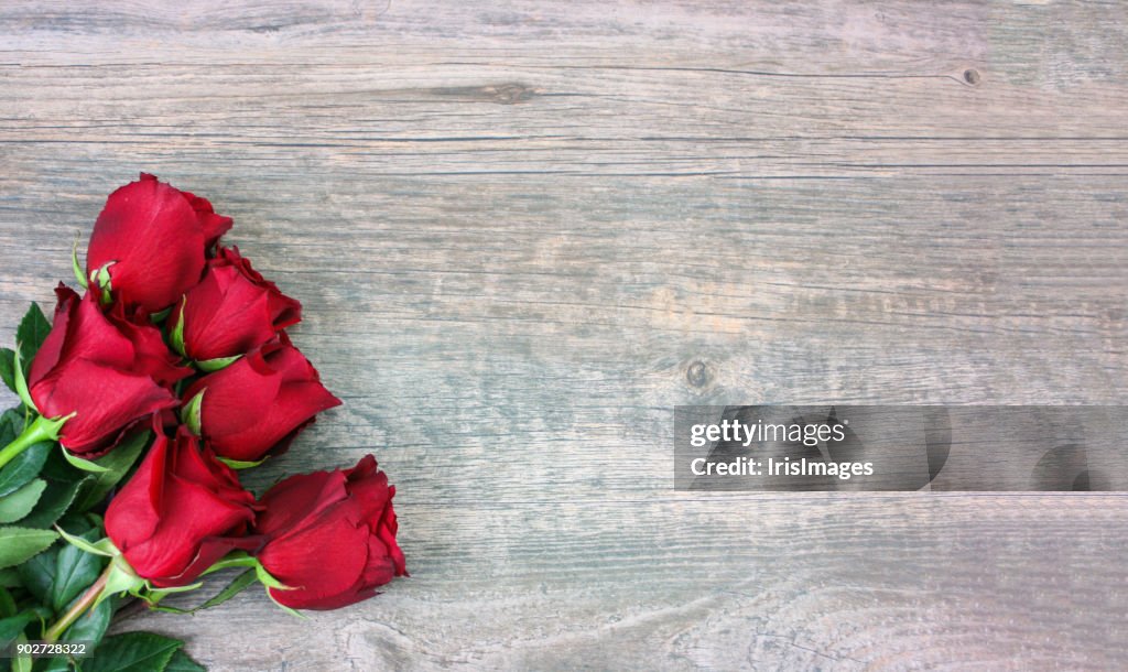 Rose rosse di San Valentino sullo sfondo del legno