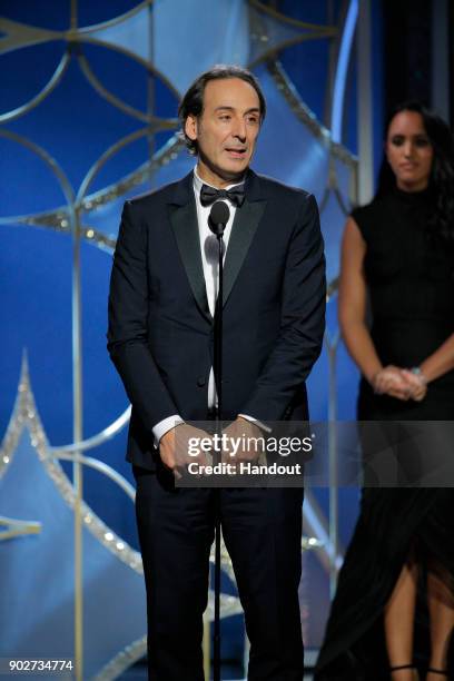 In this handout photo provided by NBCUniversal, Alexandre Desplat accepts the award for Best Original Score – Motion Picture for “The Shape of Water”...