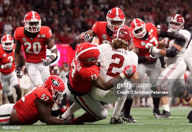 Jalen Hurts of the Alabama Crimson Tide is sacked by Jonathan Ledbetter of the Georgia Bulldogs during the first quarter in the CFP National...