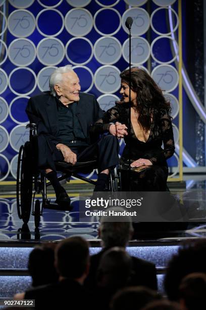 In this handout photo provided by NBCUniversal, Presenters Kirk Douglas and Catherine Zeta Jones speak onstage during the 75th Annual Golden Globe...