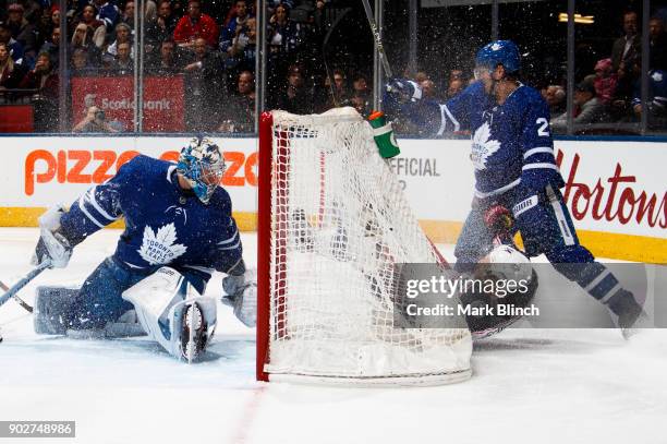 Frederik Andersen of the Toronto Maple Leafs looks for the puck as teammate Ron Hainsey takes down Jordan Schroeder of the Columbus Blue Jackets...