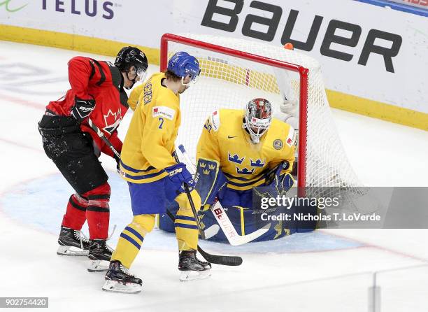 Filip Gustavsson of Sweden makes a save with Boris Katchouk of Canada and Timothy Liljegren of Sweden looking for a rebound during the second period...