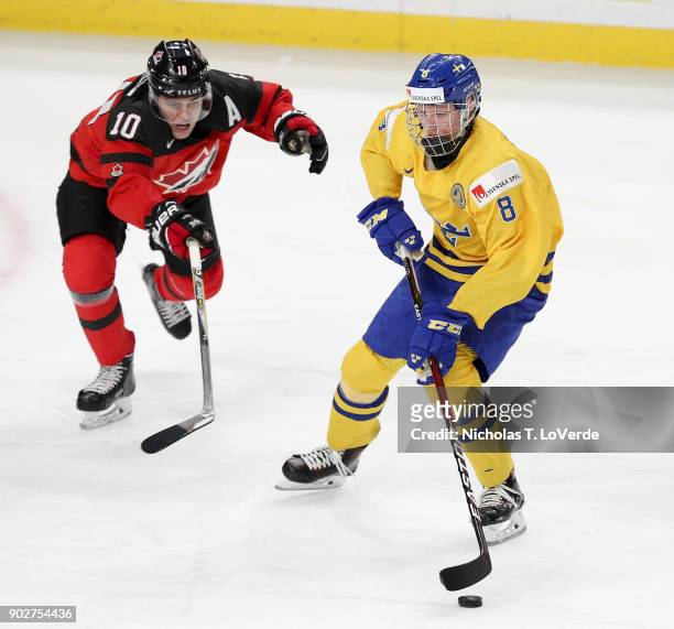 Rasmus Dahlin of Sweden skates the puck past Kale Clague of Canada during the second period of play in the IIHF World Junior Championships Gold Medal...