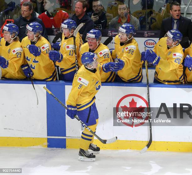 Team Sweden players congratulate Tim Söderlund for his short-handed goal against Canada that tied the game at 1-1 during the second period of play in...