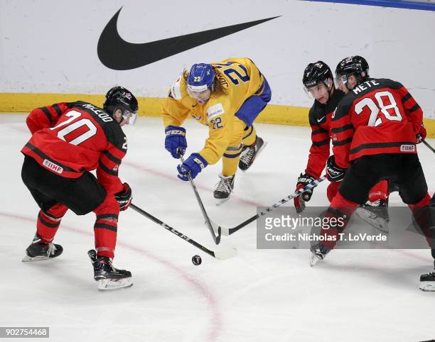 Michael McLeod of Canada and Victor Mete of Canada battle with Axel Jonsson Fjällby of Sweden for possession of the puck during the third period of...