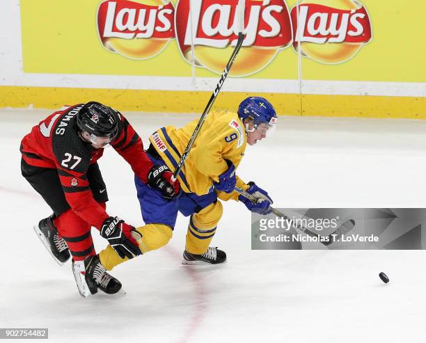Tim Söderlund of Sweden skates for a loose puck against Robert Thomas of Canada during the third period of play in the IIHF World Junior...