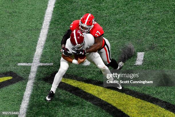 Jalen Hurts of the Alabama Crimson Tide is tackled by Davin Bellamy of the Georgia Bulldogs on a run during the second quarter in the CFP National...