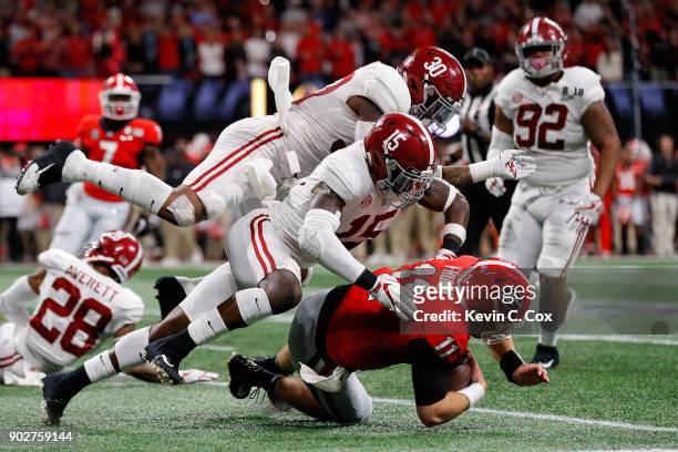 Jake Fromm of the Georgia Bulldogs is tackled by Ronnie Harrison and Mack Wilson of the Alabama Crimson Tide during the second quarter in the CFP...