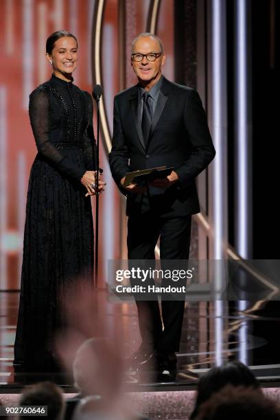 In this handout photo provided by NBCUniversal, Presenters Alicia Vikander and Michael Keaton speak onstage during the 75th Annual Golden Globe...