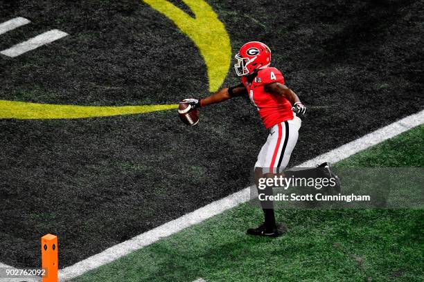 Mecole Hardman of the Georgia Bulldogs runs one yard for a touchdown during the second quarter against the Alabama Crimson Tide in the CFP National...