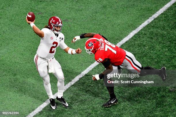 Jalen Hurts of the Alabama Crimson Tide throws a pass under pressure from Trenton Thompson of the Georgia Bulldogs during the second quarter in the...