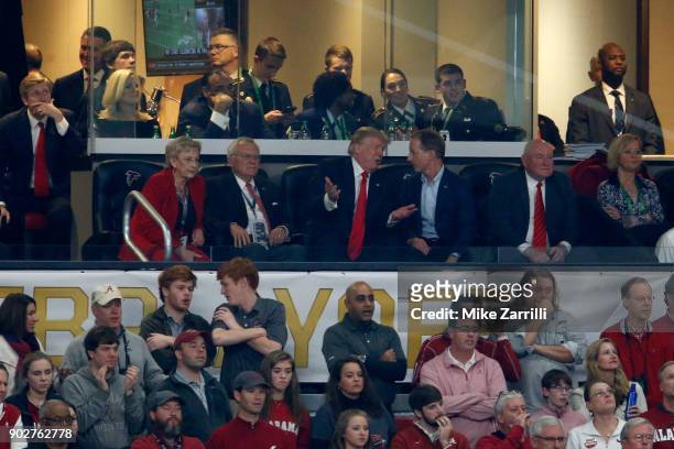 President Donald Trump talks to Georgia Governor Nathan Deal and his wife Sandra Dunagan during the second quarter of the CFP National Championship...