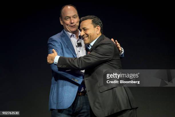 Tim Baxter, president and chief executive officer of Samsung Electronics America Inc., left, greets Dinesh Paliwal, president and chief executive...