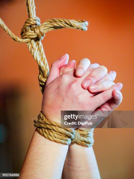 woman’s hands tied up with jute rope - tied up ストックフォトと画像