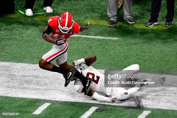 Mecole Hardman of the Georgia Bulldogs manages to stay in bounds for an 80 yard touchdown reception against Tony Brown of the Alabama Crimson Tide...