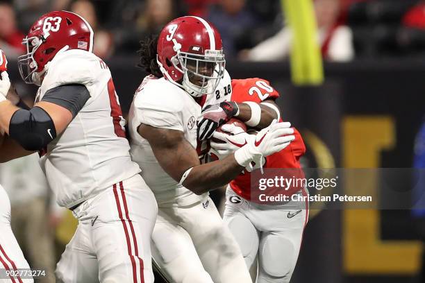 Bo Scarbrough of the Alabama Crimson Tide is tackled by J.R. Reed of the Georgia Bulldogs during the second half in the CFP National Championship...