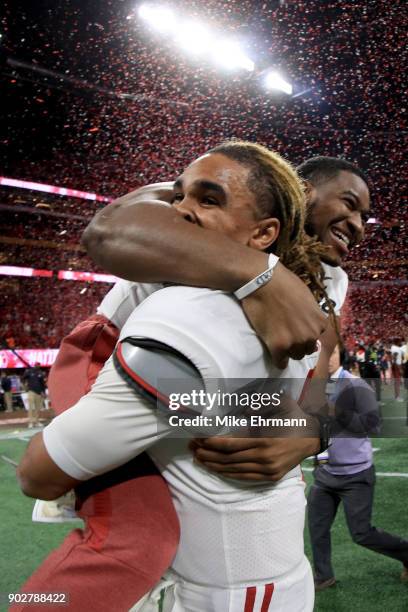 Jalen Hurts and Shaun Dion Hamilton of the Alabama Crimson Tide celebrate beating the Georgia Bulldogs in overtime to win the CFP National...