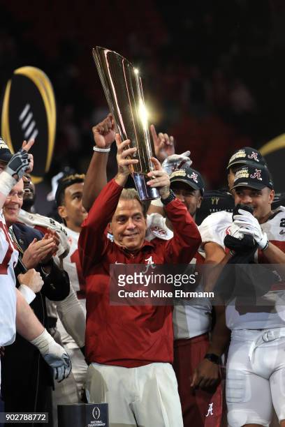 Head coach Nick Saban of the Alabama Crimson Tide holds the trophy while celebrating with his team after defeating the Georgia Bulldogs in overtime...