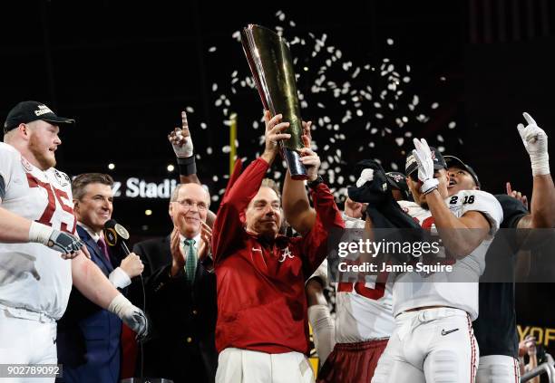 Head coach Nick Saban of the Alabama Crimson Tide holds the trophy while celebrating with his team after defeating the Georgia Bulldogs in overtime...