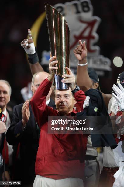 Head coach Nick Saban of the Alabama Crimson Tide holds the trophy while celebrating with his team after defeating the Georgia Bulldogs in overtime...