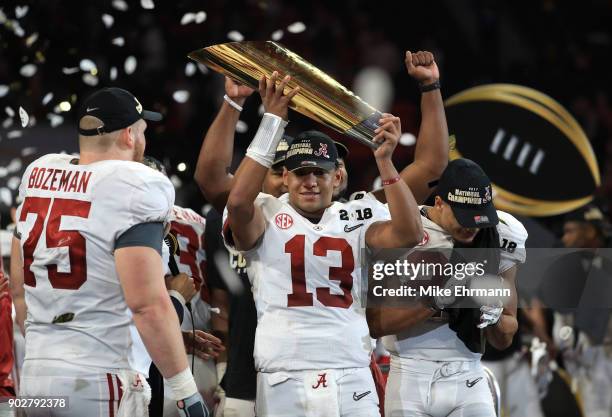 Tua Tagovailoa of the Alabama Crimson Tide holds the trophy while celebrating with his team after defeating the Georgia Bulldogs in overtime to win...