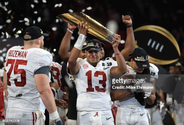 Tua Tagovailoa of the Alabama Crimson Tide holds the trophy while celebrating with his team after defeating the Georgia Bulldogs in overtime to win...