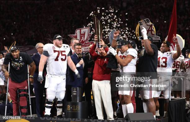 Head coach Nick Saban of the Alabama Crimson Tide holds the trophy while celebrating with his team after defeating the Georgia Bulldogs in overtime...