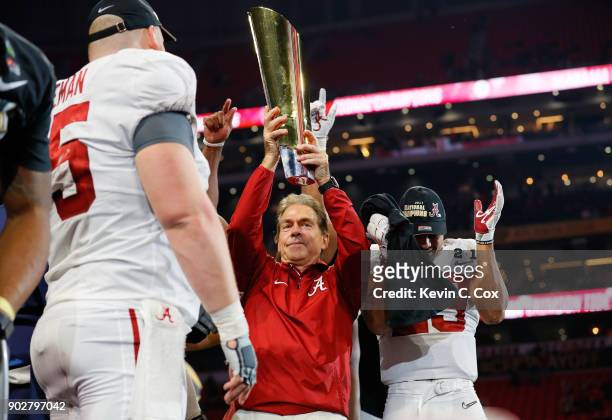 Head coach Nick Saban of the Alabama Crimson Tide holds the trophy while celebrating with his team after defeating the Georgia Bulldogs in overtime...