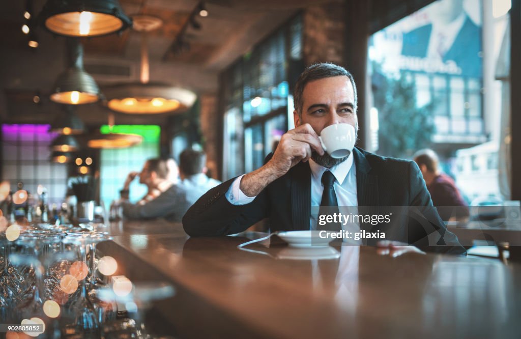 Homem ter um café em um bar da manhã