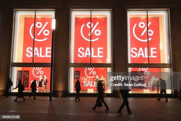 People past display windows offering post-Christmas sales outside a department store at Alexanderplatz on January 8, 2018 in Berlin, Germany. Many...