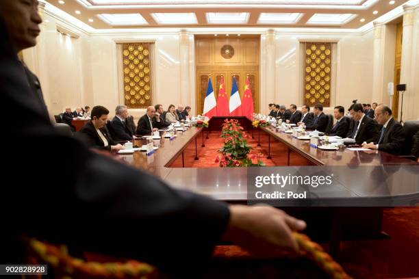 An attendant takes up a rope line during a meeting between French President Emmanuel Macron and Chinese Premier Li Keqiang at the Great Hall of the...