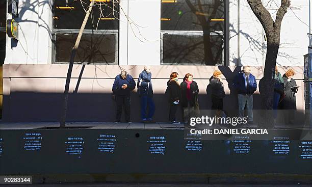 Retired people line up outside a bank to cash their retirement pensions in Buenos Aires' La Boca neighbourhood on August 18, 2009. La Boca is widely...