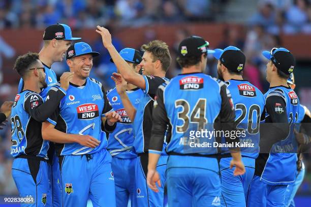 Ben Laughlin of the Adelaide Strikers celebrates with his team mates after Alex Carey of the Adelaide Strikers takes a catch to dismiss Peter...