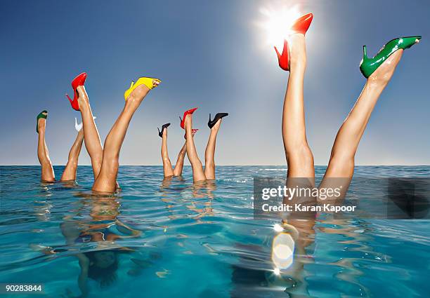 group of legs portruding out of infinity pool - colorful shoes ストックフォトと画像