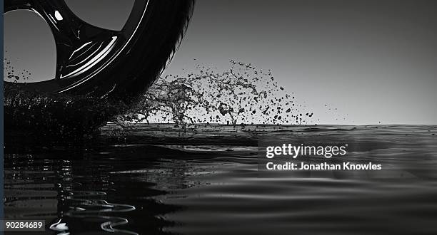 car tyre creating water splash - tyre side view foto e immagini stock