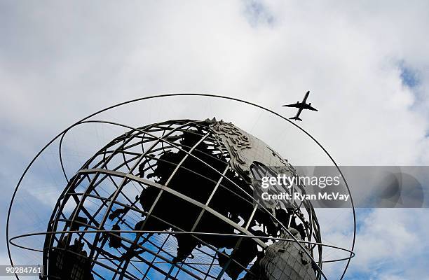 plane flying over world's fair globe, new york - queens globe stock pictures, royalty-free photos & images