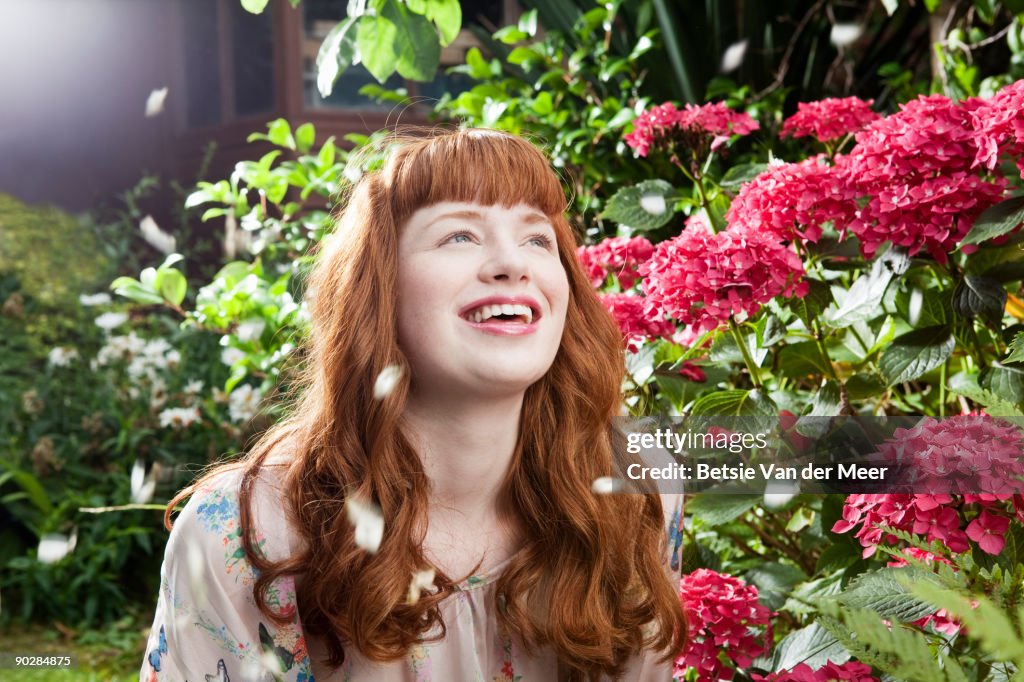 Woman laughing while showered by flowerpedals 