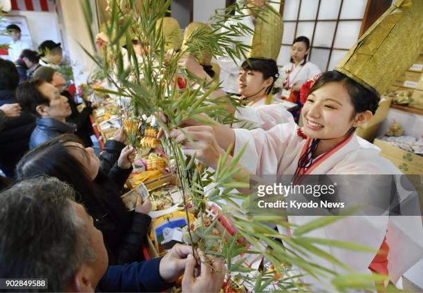 "Fuku musume," or lucky girls, put lucky charms on visitors' bamboo branches at the Imamiya Ebisu Shrine in Osaka on Jan. 9 the first day of the...