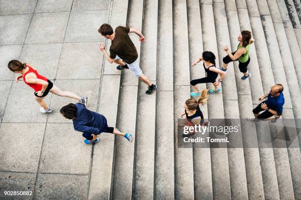 grupo de atletas aficionados corriendo juntos en la ciudad - ropa de deporte fotografías e imágenes de stock