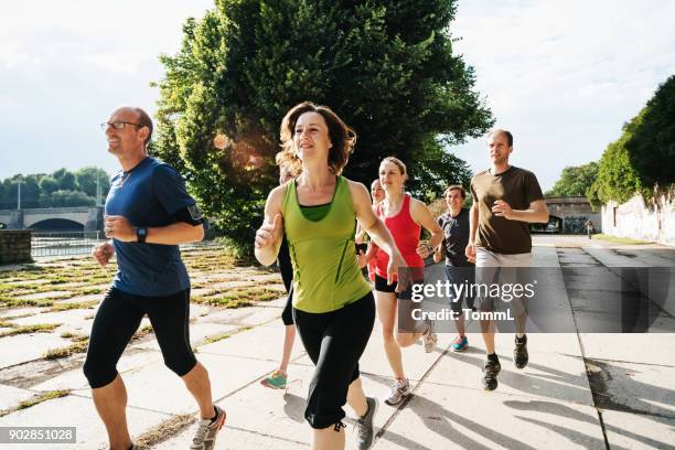 grupo de atletas amateur entrenando juntos al aire libre en ciudad sol - aerobismo fotografías e imágenes de stock