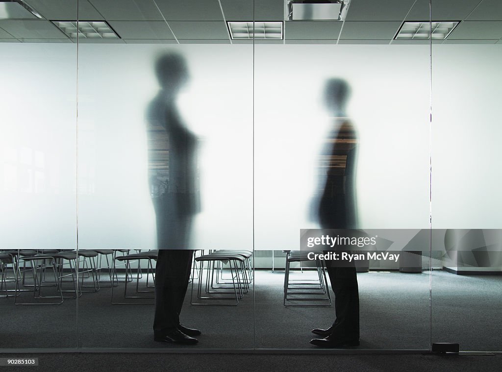 Silhouettes of business men in conference room