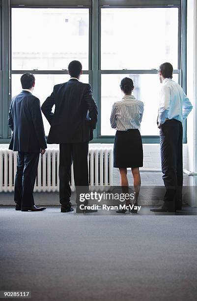 business team looking out window - four people foto e immagini stock