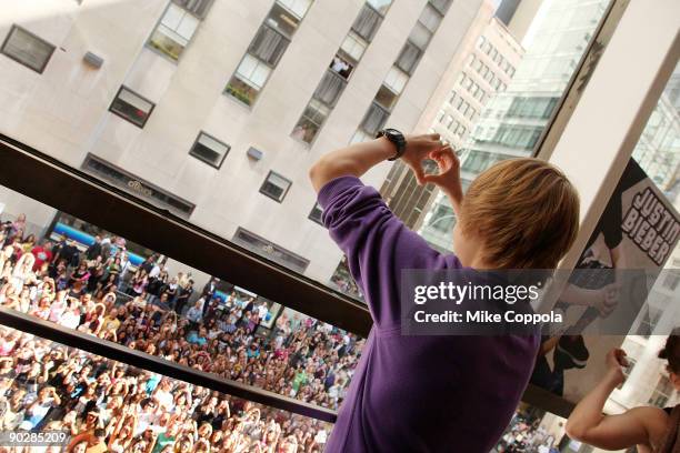 Singer Justin Bieber makes a heart sign to fans outside of the Nintendo World Store on September 1, 2009 in New York City.