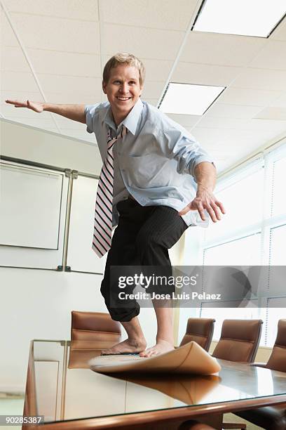 young businessman surfing on desk - hochgekrempelte hose stock-fotos und bilder