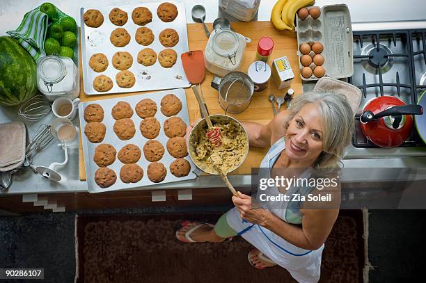 mature woman making cookies, overhead perspective. - mixing bowl stock pictures, royalty-free photos & images