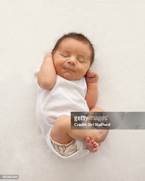 newborn baby boy, curled up in fetal position - baby stockfoto's en -beelden