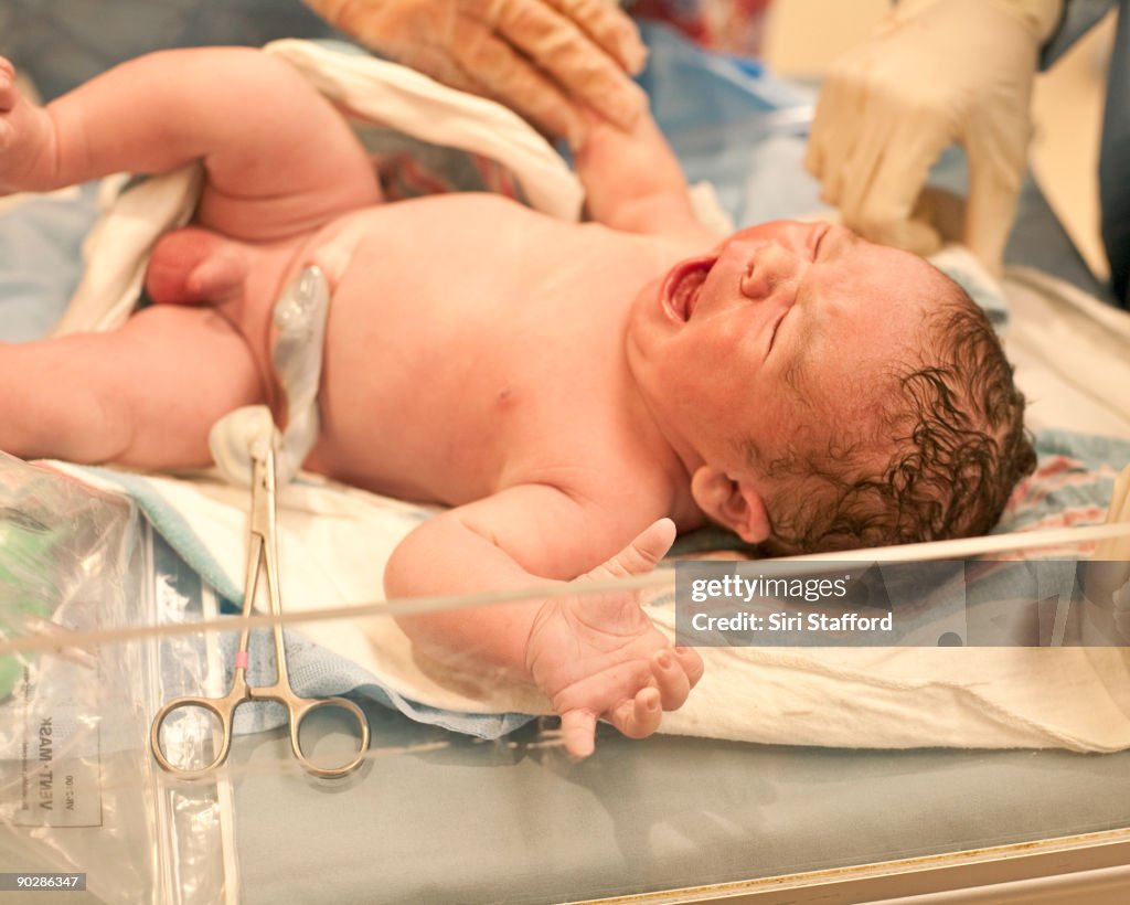 Newborn baby boy crying after birth